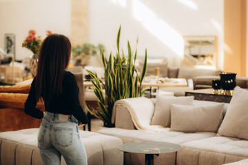 a woman examines a sofa in a furniture store