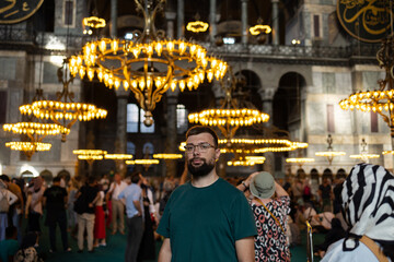 SEPTEMBER 2023, ISTANBUL, TURKEY: male tourist in Hagia Sophia, against the backdrop of a huge...