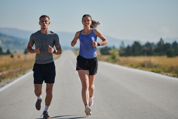 Energized by the beauty of nature, a couple powers through their morning run, their bodies and...