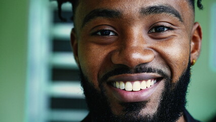 One happy young black hispanic man from South America smiling with wide grin in tight macro...
