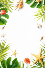 Tropical leaves and sea shells on white background. Summer flat lay background with copy space.