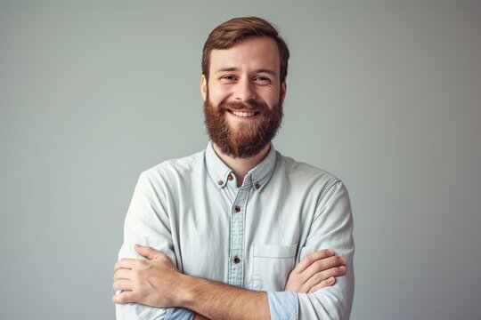 a man with beard smiling with arms crossed
