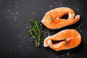 Salmon fish fresh salmon steak with spices on black table. Flat lay.