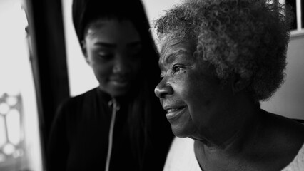 Pensive African American Senior woman staring at a distance with contemplative gaze, granddaughter...