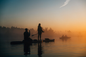 silhouette of a people watching sunrise in swamp lake