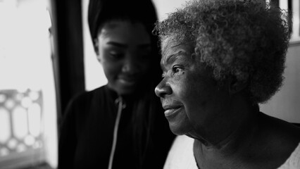 Pensive African American Senior woman staring at a distance with contemplative gaze, granddaughter...
