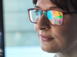 Professional women designing a pie diagram on a computer to illustrate business statistics.