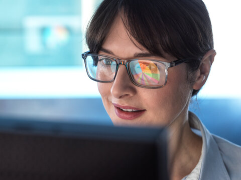 Professional women designing a pie diagram on a computer to illustrate business statistics.
