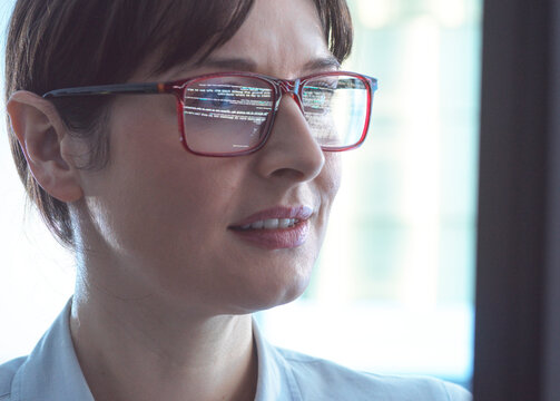 Female programmer designing code on a computer screen in the office.