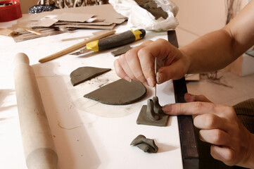 Artisan shaping clay in a pottery workshop.