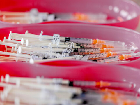 A variety of medical syringes stacked together.
