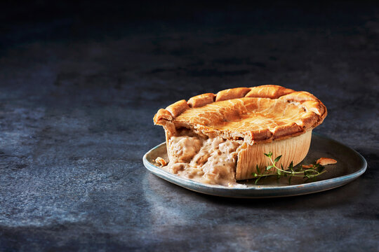 A mouthwatering chicken pot pie served on a rustic plate garnished with fresh herbs.