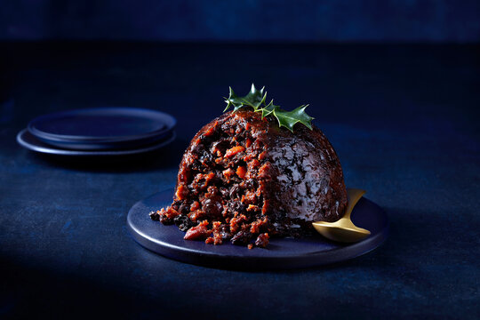A delicious slice of traditional fruitcake on a dark, elegant background, perfect for festive celebrations.