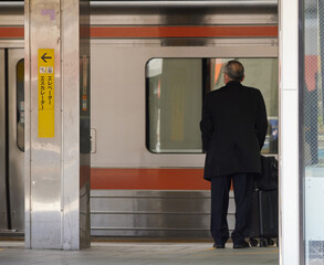 朝の通勤時間のJR名古屋駅のホームで電車待ちの人々の姿