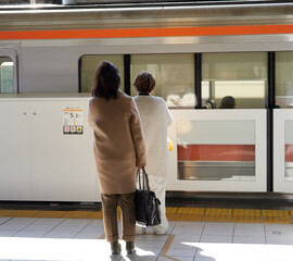 朝の通勤時間のJR名古屋駅のホームで電車待ちの人々の姿