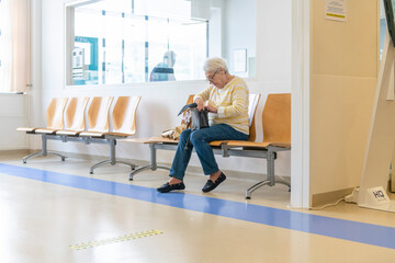 Elderly woman waiting patiently on a hospital bench