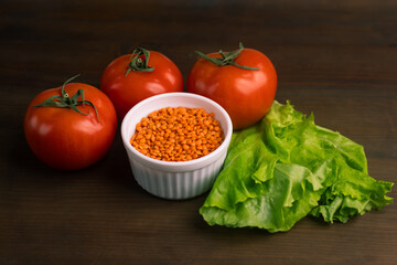 Tomatoes lentils green salad on brown background