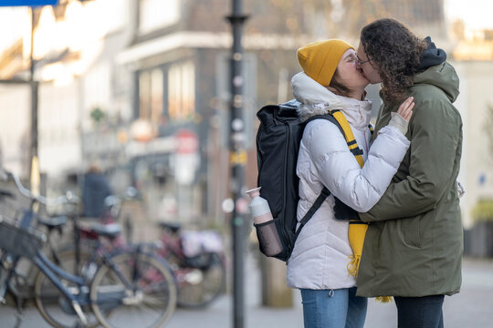 Couple sharing a kiss on a city street.
