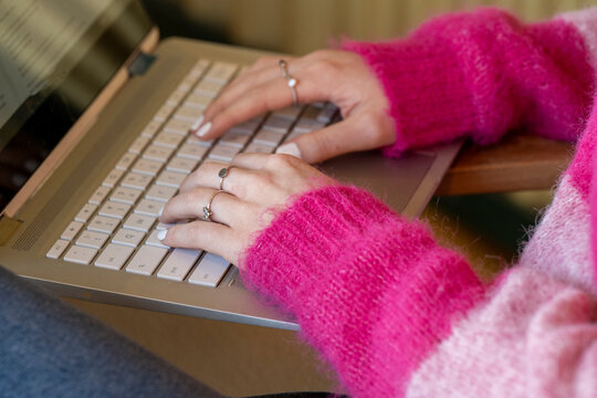 Hands typing on a laptop keyboard