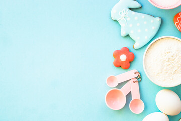 Easter baking, Flour, edds, sugar and gingerbread cookies. Top view on blue.