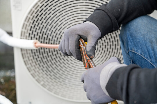 A technician servicing an outdoor air conditioning unit.