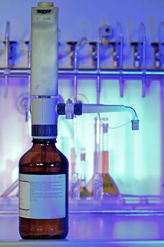Laboratory precision: A burette carefully positioned over a chemical bottle