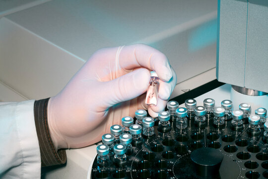 Scientist inserting a sample into an analytical machine in a laboratory