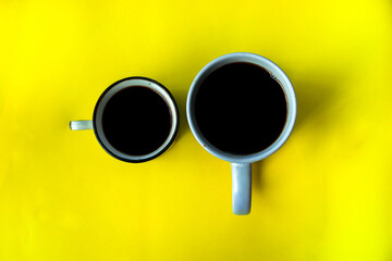 two cups of coffee with top view on a yellow background