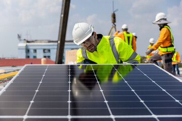 Fototapeta premium Engineer service check installation solar cell on the roof of factory. Engineers walking on roof inspect and check solar cell panel. Engineer working inspection installation solar cell on the roof