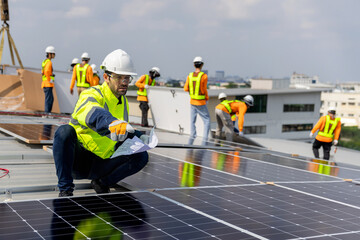 Technicians Install photovoltaic solar modules on roof of factory. Engineers install or fix solar...