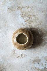 A flat ceramic vase handmade in sunlight, in harsh shadows. View from above. A minimalistic concept for the design of a modern interior.