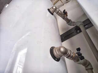 An intricate array of pipes and valves behind the scenes. Complex Plumbing Configuration Behind a...