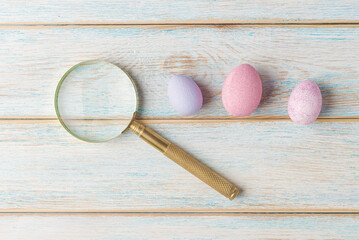 Magnifying Glass and Colorful Eggs on Wooden Surface - 757242918