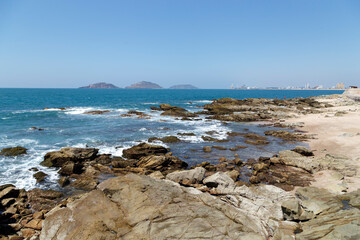 Playa soleada con piedras y olas rompiendose en las rocas. Mazatlan, Sinaloa. Océano Pacífico