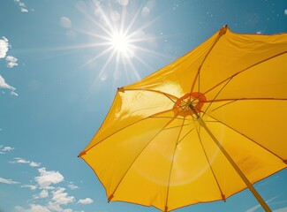 A yellow beach umbrella against the blue sky, protection from the sun.