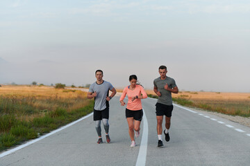 A group of friends, athletes, and joggers embrace the early morning hours as they run through the misty dawn, energized by the rising sun and surrounded by the tranquil beauty of nature