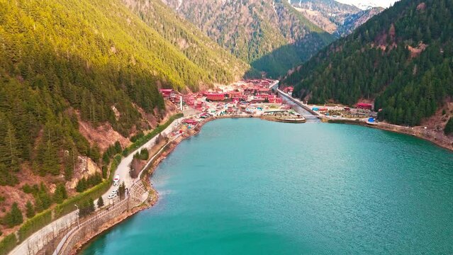 aerial view of a lake with a bridge and a mountain in the background
