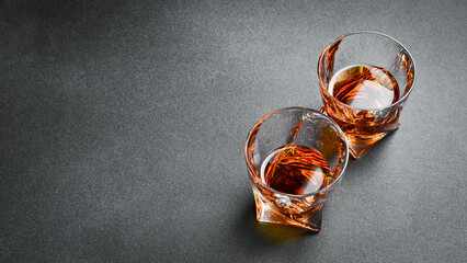 Two glasses of strong alcohol: whiskey, rum or bourbon. Strong aged alcoholic drinks. - obrazy, fototapety, plakaty