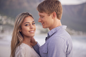 Couple, portrait and love in touch by beach, ocean waves and peace for romance in relationship. People, affection and security in marriage, sea and travel together on vacation or holiday for date