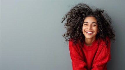 Radiant young woman laughing in vibrant red sweater