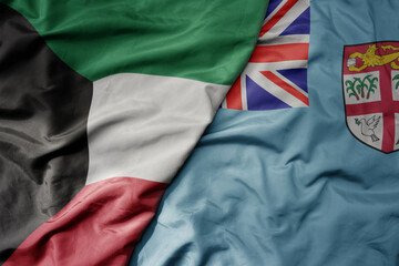 big waving national colorful flag of Fiji and national flag of kuwait.