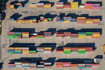 Top down view of colorful containers piles in port container terminal, industrial cargo harbor