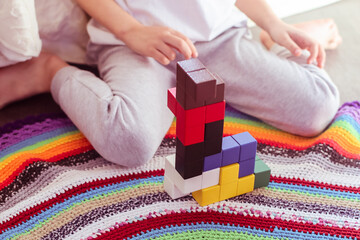 wooden logic game in the form of cubes close-up and a boy playing with it