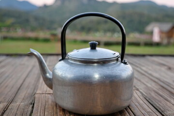 Traditional old-fashioned kettle made from aluminum, handle made from bakelite painted black, used...