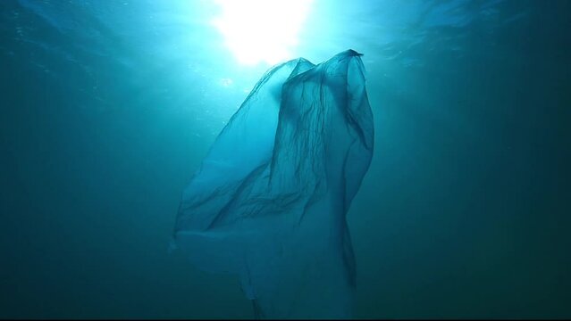 Beautiful underwater view, in a lowangle shot, of a blue plastic bag illuminated by sunlight filtering through the surface Check my portfolio for similar footage