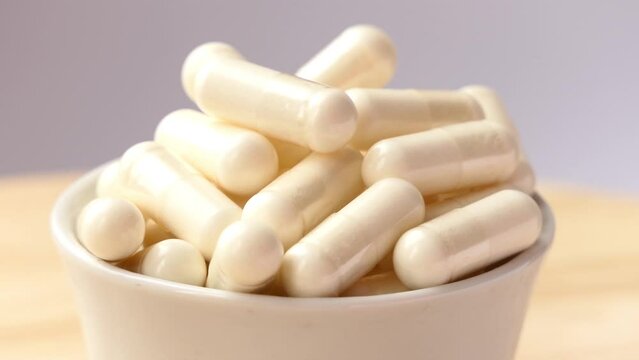 cup with pills spinning on wooden board
