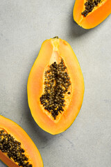Close up of exotic papaya fruit. Sliced papaya on a gray concrete background.