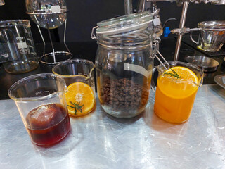 Good quality coffee beans in a glass jar which is coffee water Lemon juice and lemon slices in a glass Ingredients to customize and experiment with making coffee mixed with lemonade in the laboratory.