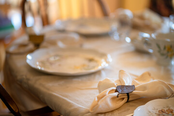 A table with a white tablecloth and a white napkin with a black ring on it