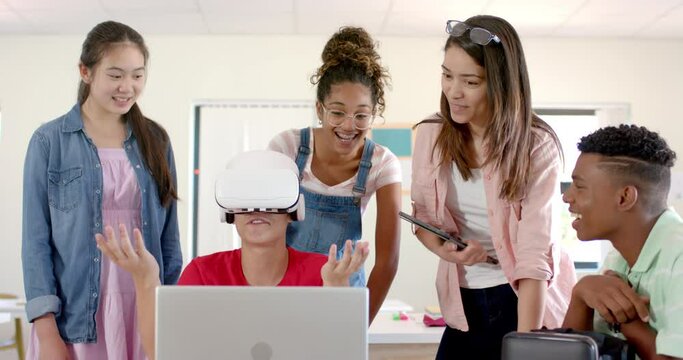 Diverse group of teenagers in high school explores virtual reality, with one wearing a VR headset
